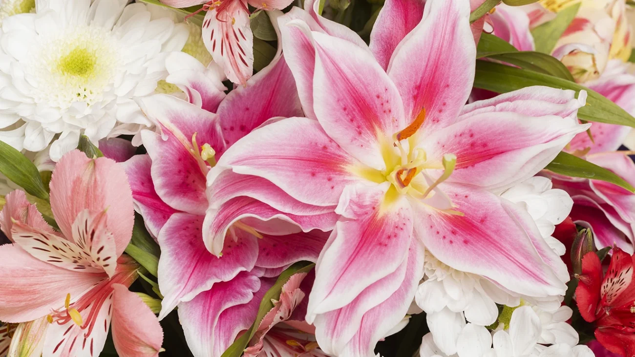 Ramo primaveral con lirios y margaritas artificiales en tonos claros, ideal para catálogo de floristería y decoración de temporada.