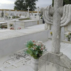 Centro funerario artificial con flores blancas y verdes preparado para campaña de difuntos.