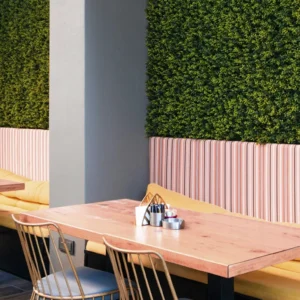 Lobby de hotel con decoración tropical y palmeras XL artificiales en interior de estilo resort.