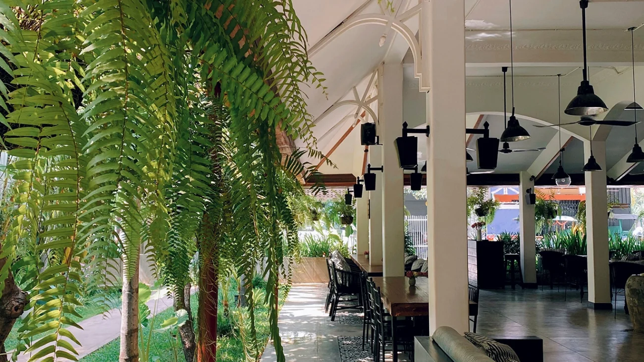 Terraza de restaurante renovada con plantas artificiales para verano.