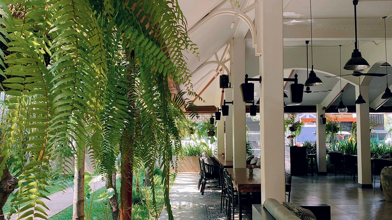 Terraza de restaurante renovada con plantas artificiales para verano.